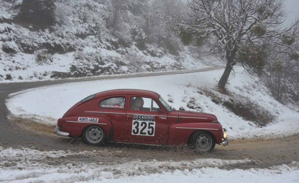 Ein Bild eines roten Oldtimers in einer Rennkurve